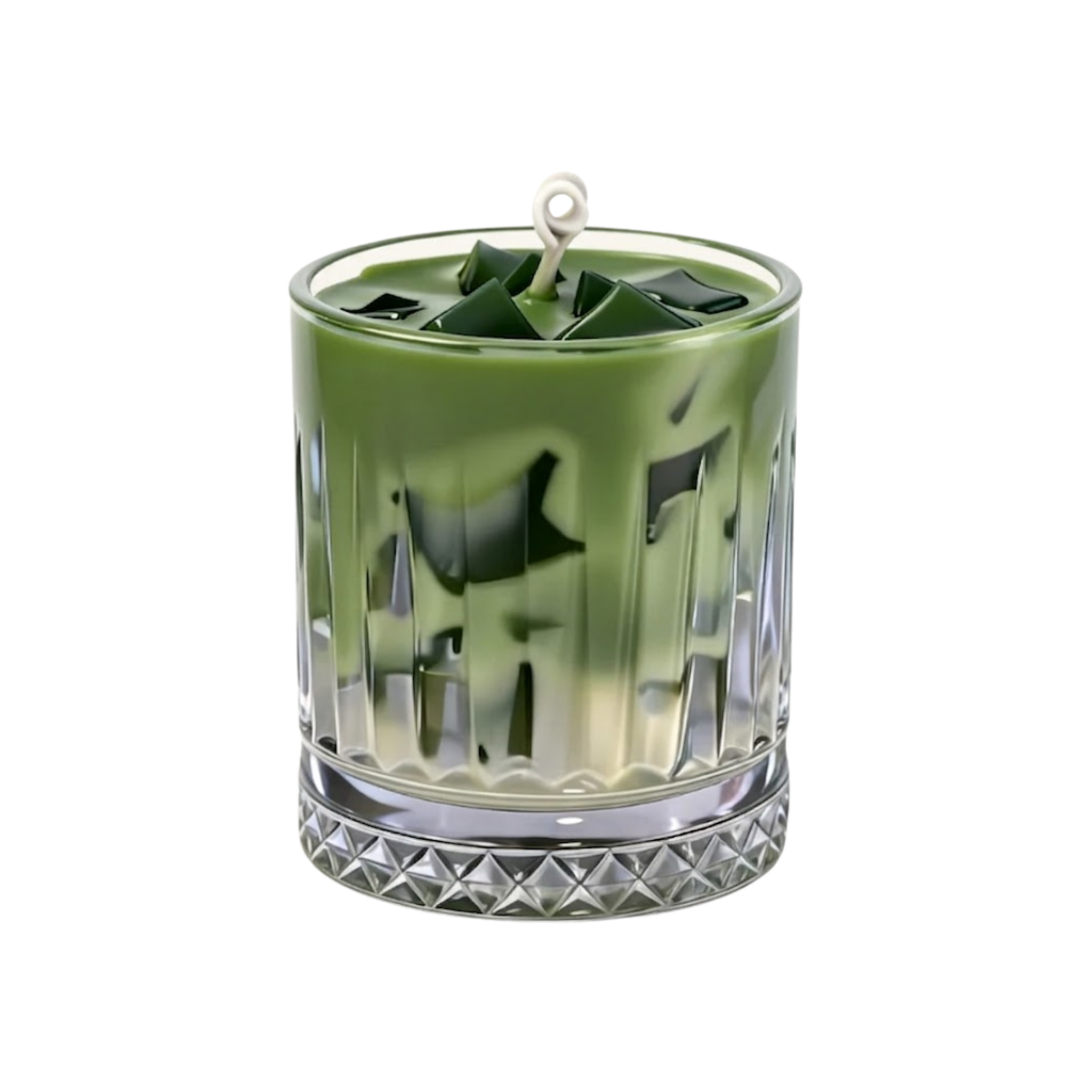 A green wax candle in a clear, faceted glass tumbler with a textured diamond-cut base, featuring a white wick at the top, set against a plain white background.